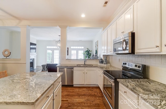 kitchen featuring sink, appliances with stainless steel finishes, white cabinetry, dark hardwood / wood-style floors, and ornate columns