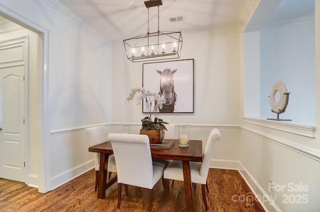 dining space with crown molding and hardwood / wood-style floors