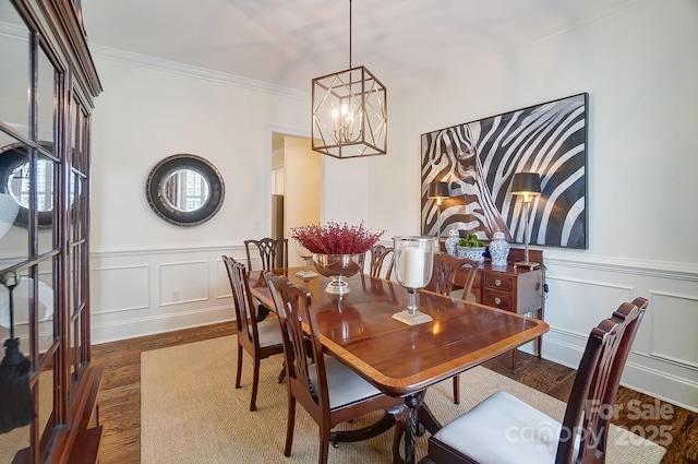 dining area with ornamental molding, dark hardwood / wood-style floors, and an inviting chandelier