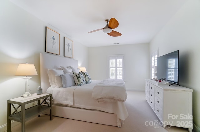 bedroom featuring light colored carpet and ceiling fan