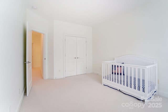 bedroom featuring carpet, a closet, and a crib