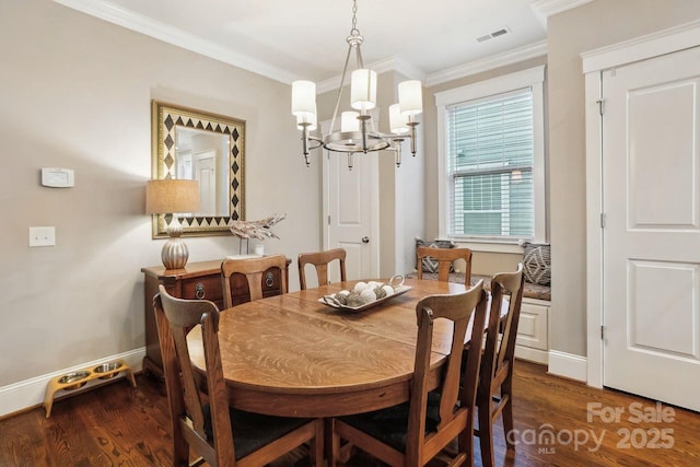 dining space featuring crown molding, dark wood-type flooring, and a chandelier