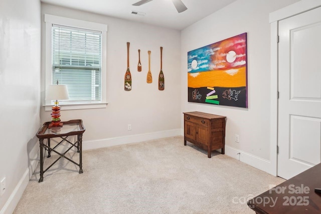 living area with ceiling fan and light colored carpet