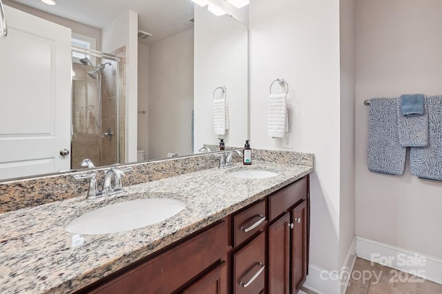 bathroom with tile patterned floors, vanity, toilet, and a shower with shower door