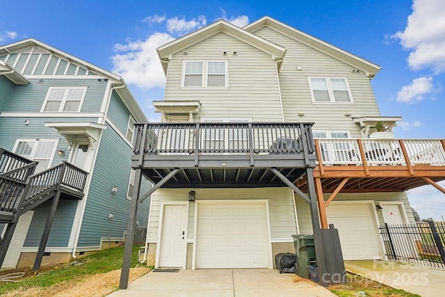 rear view of house featuring a wooden deck and a garage