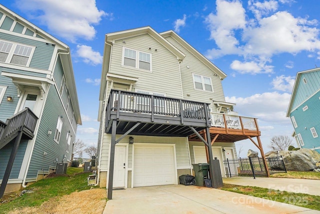 rear view of house featuring cooling unit, a garage, and a wooden deck