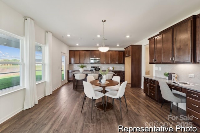 dining area with dark wood-type flooring and built in desk