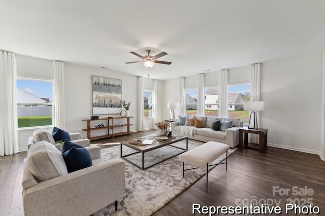 living room featuring dark wood-type flooring and ceiling fan