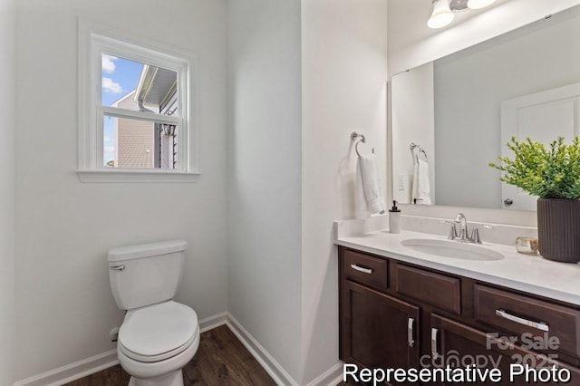 bathroom featuring vanity, hardwood / wood-style floors, and toilet