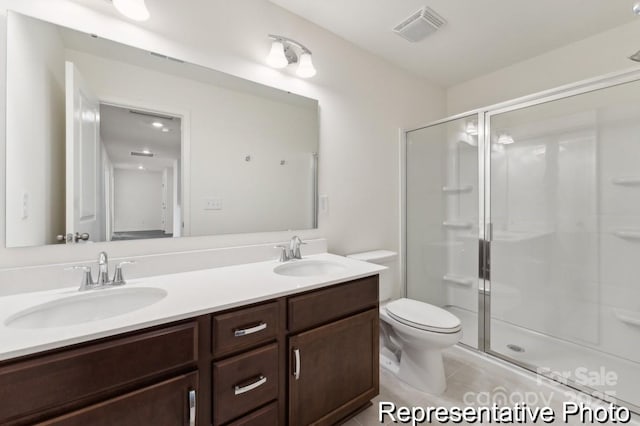 bathroom with tile patterned flooring, vanity, toilet, and walk in shower