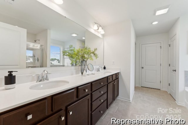 bathroom with walk in shower, vanity, and tile patterned flooring