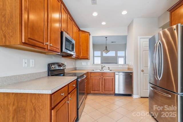 kitchen featuring sink, decorative light fixtures, light tile patterned floors, and appliances with stainless steel finishes