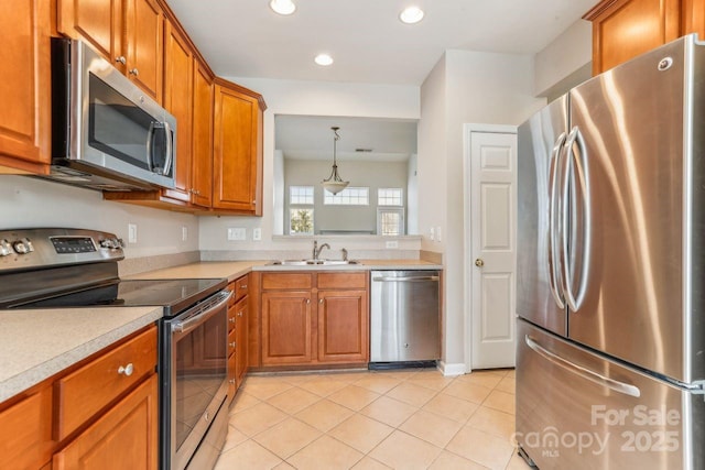 kitchen featuring pendant lighting, sink, light tile patterned flooring, and appliances with stainless steel finishes