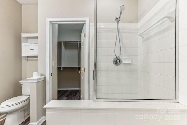 bathroom featuring toilet and tiled shower