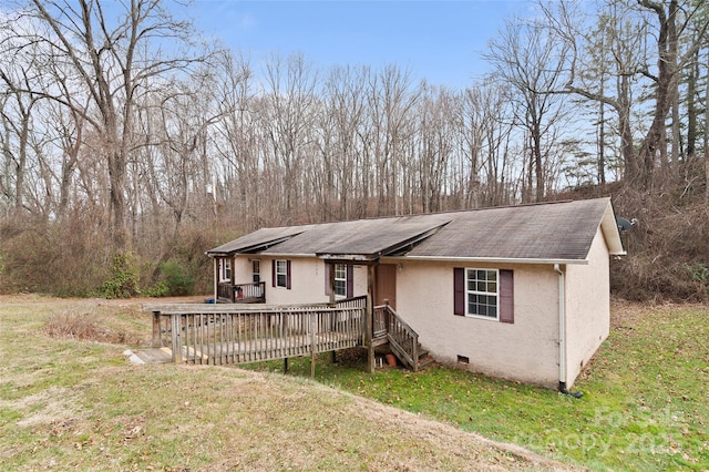 view of front of house with a wooden deck and a front lawn