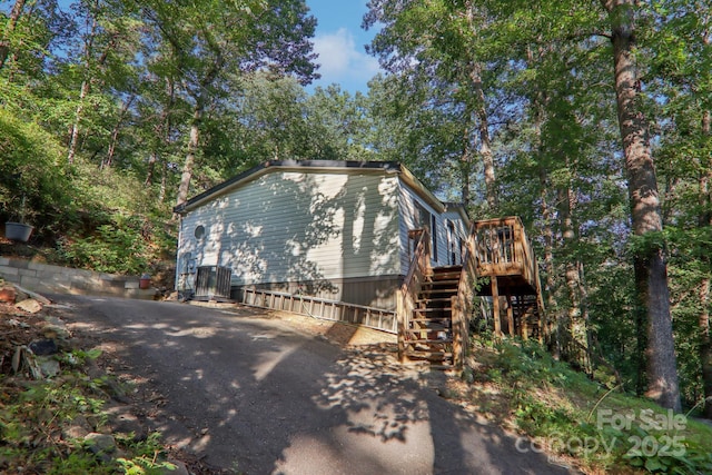 view of property exterior featuring a wooden deck and central AC unit