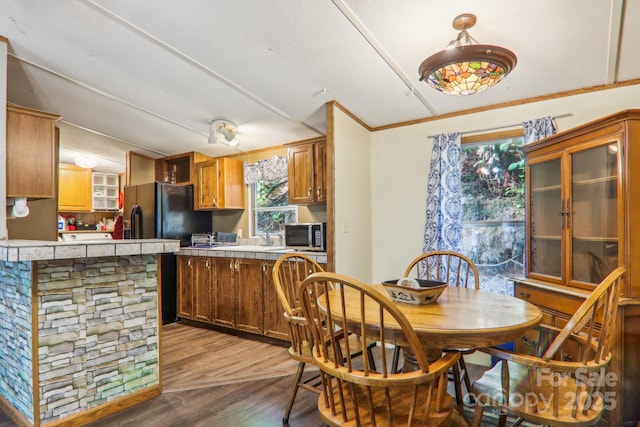 kitchen featuring black fridge with ice dispenser and hardwood / wood-style floors