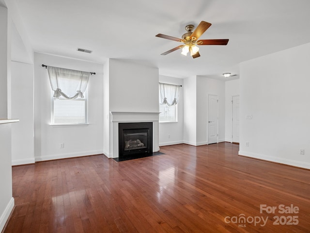 unfurnished living room featuring dark hardwood / wood-style flooring and ceiling fan