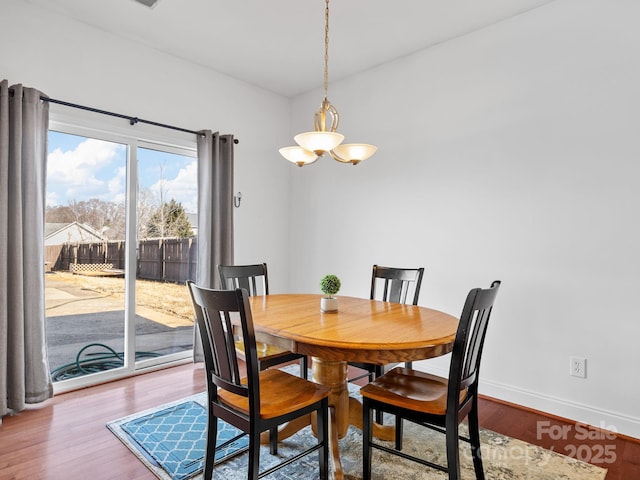 dining room with wood-type flooring and a notable chandelier