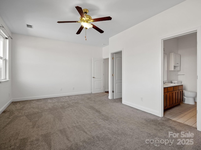 unfurnished bedroom with connected bathroom, light carpet, and ceiling fan