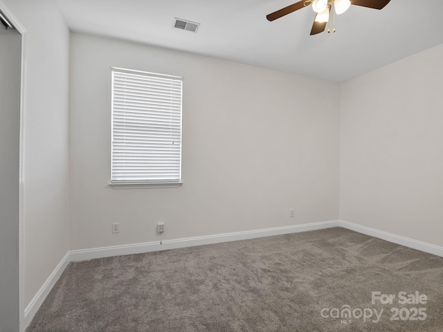 carpeted spare room with ceiling fan