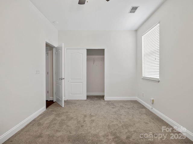 unfurnished bedroom with light colored carpet, a closet, and ceiling fan