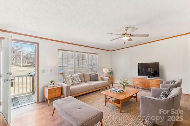 living area with a healthy amount of sunlight, crown molding, and light wood finished floors