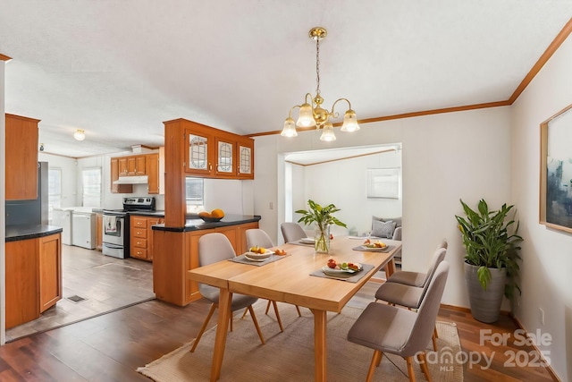 dining space featuring an inviting chandelier, ornamental molding, and wood finished floors