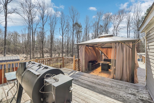 wooden deck with a gazebo and area for grilling