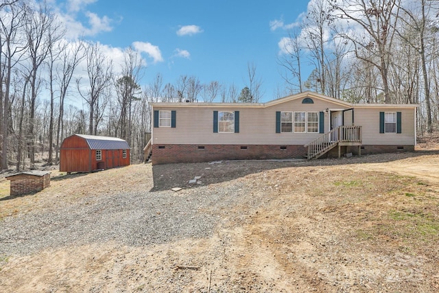 manufactured / mobile home with crawl space, an outdoor structure, and a storage shed