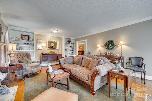 living room featuring built in features, ornamental molding, hardwood / wood-style floors, and a textured ceiling