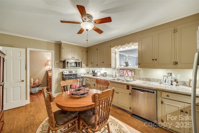 kitchen with sink, light hardwood / wood-style flooring, ornamental molding, appliances with stainless steel finishes, and ceiling fan