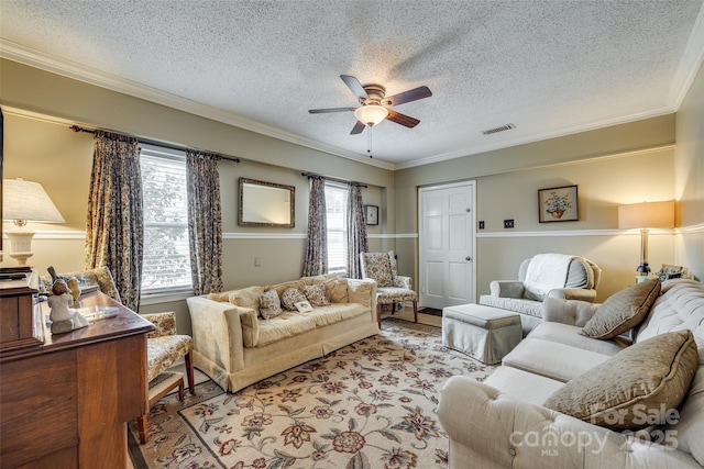 living room featuring crown molding, light hardwood / wood-style flooring, a textured ceiling, and ceiling fan