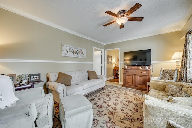 living room featuring a textured ceiling, ornamental molding, and ceiling fan