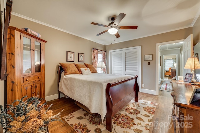 bedroom with crown molding, ceiling fan, light hardwood / wood-style floors, and a closet