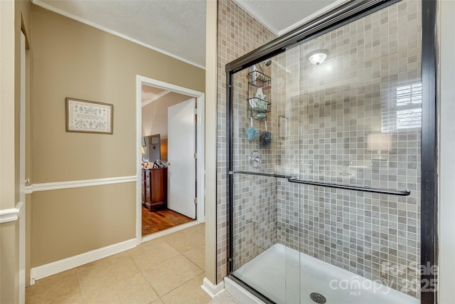 bathroom featuring tile patterned flooring, crown molding, a textured ceiling, and walk in shower