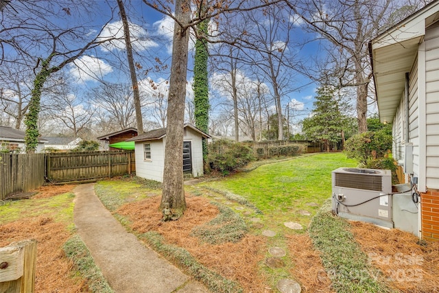 view of yard with central AC unit and a storage unit