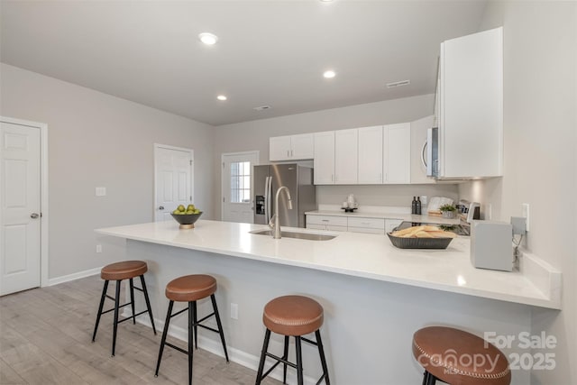 kitchen with stainless steel appliances, a breakfast bar, sink, and kitchen peninsula