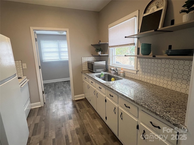 kitchen with sink, white refrigerator, light stone countertops, decorative backsplash, and white cabinets