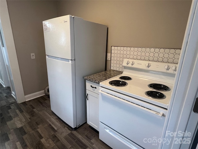 kitchen with white cabinetry, white appliances, dark wood-type flooring, and dark stone countertops