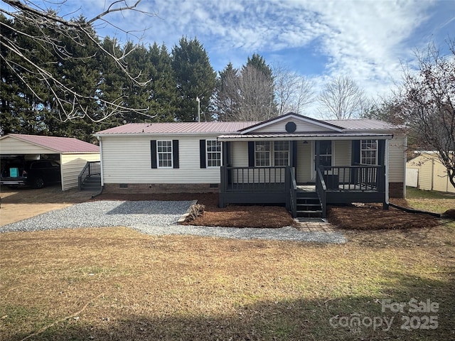 manufactured / mobile home featuring a front lawn, a carport, and a porch