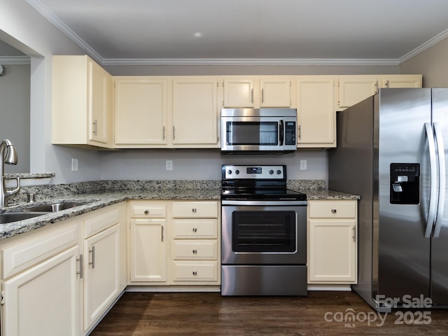 kitchen with sink, stainless steel appliances, crown molding, light stone countertops, and cream cabinetry