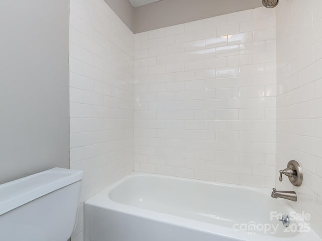 bathroom featuring tiled shower / bath and toilet