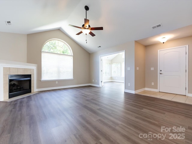 unfurnished living room with dark hardwood / wood-style flooring, a fireplace, ceiling fan, and vaulted ceiling