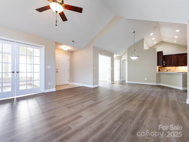 unfurnished living room with wood-type flooring, high vaulted ceiling, and ceiling fan