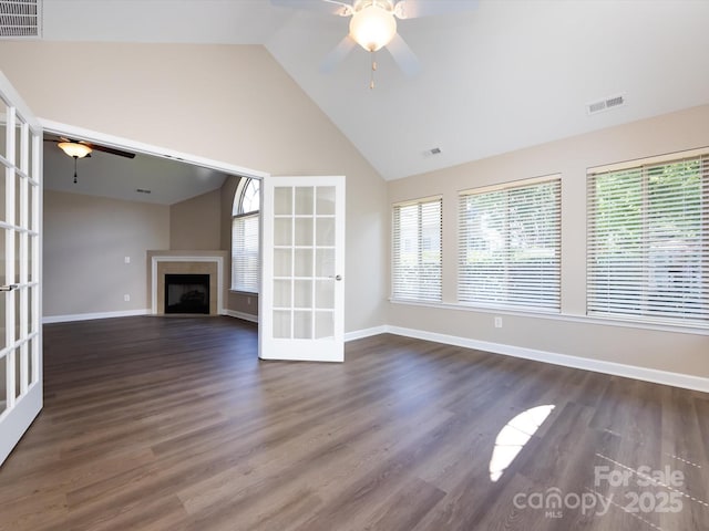 unfurnished living room featuring a healthy amount of sunlight, ceiling fan, and french doors