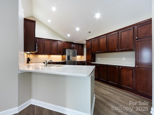 kitchen featuring sink, hardwood / wood-style floors, stainless steel fridge, and kitchen peninsula