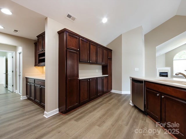 kitchen with lofted ceiling, sink, dishwasher, dark brown cabinets, and light hardwood / wood-style floors