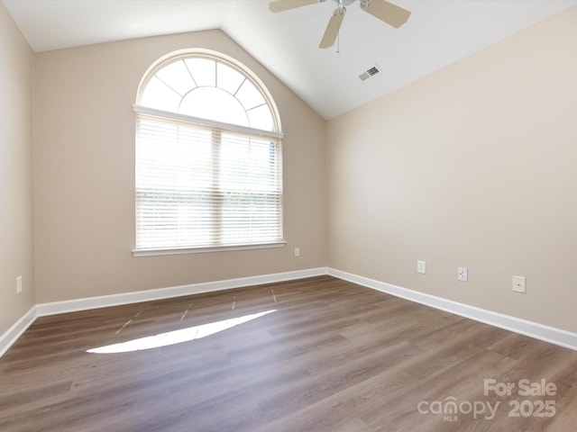 empty room with dark wood-type flooring, ceiling fan, and lofted ceiling