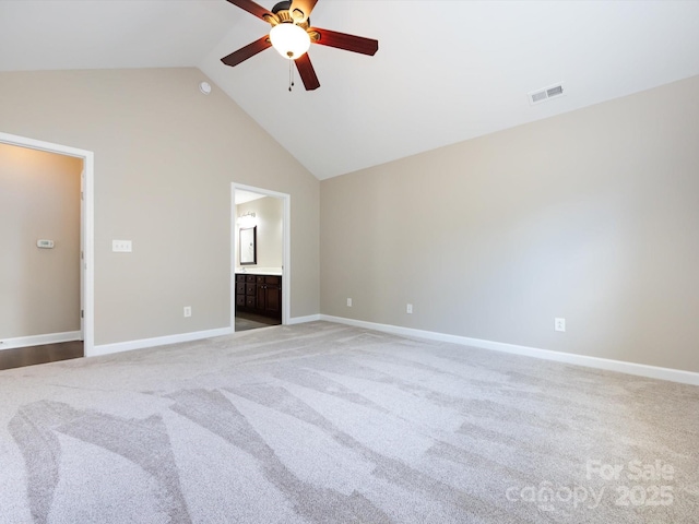 interior space featuring light carpet, high vaulted ceiling, ceiling fan, and ensuite bathroom